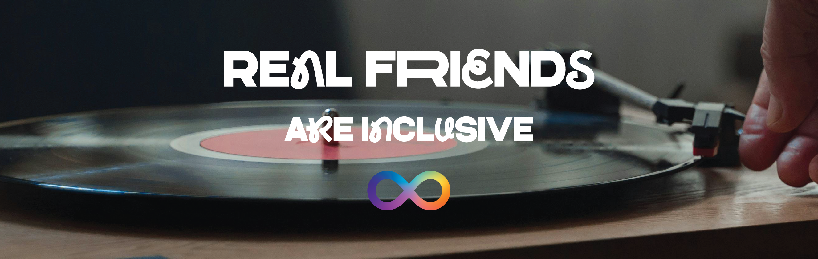 Turntable with a hand placing a record on it, featuring text 'Real friends are inclusive' and a rainbow infinity sign logo.